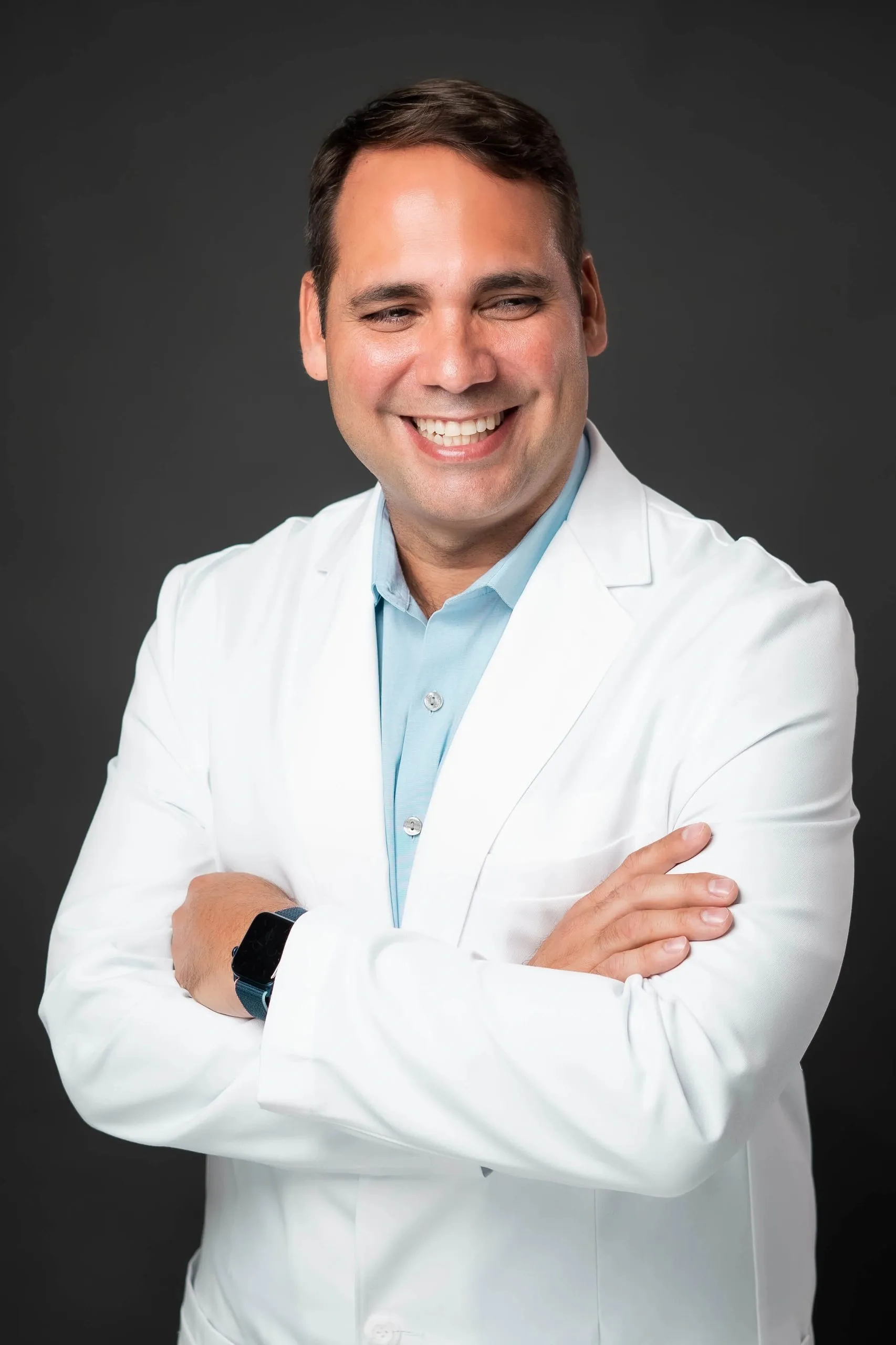 Dr. Lionel E. Lázaro Collazo con bata blanca y brazos cruzados