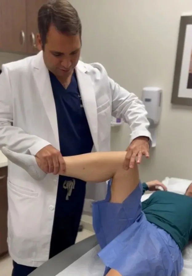 El Dr. Lázaro examinando la rodilla de un paciente